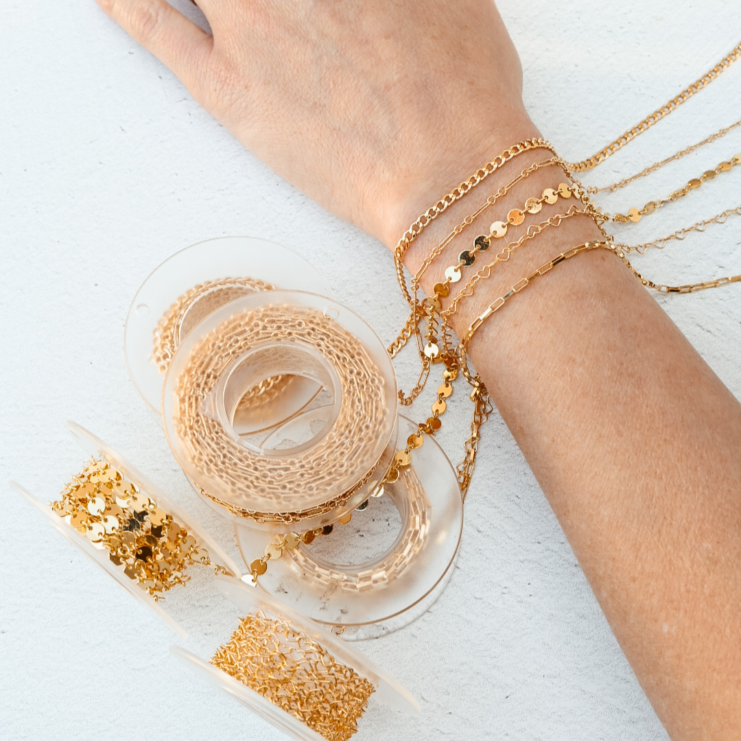 Permanent Jewelry chain options laying on a woman's wrist.